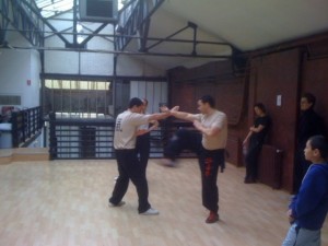 A partir d'une situation croisée, en position "T", attaque directe de la jambe en wing chun kung fu, le Bil Sao (bras lancé) établi le contact avec l'adversaire